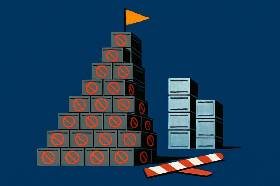 A tall tower of stacked grey server crates marked with red prohibition symbols rising higher than sleeker silver stacks, past a broken border barrier